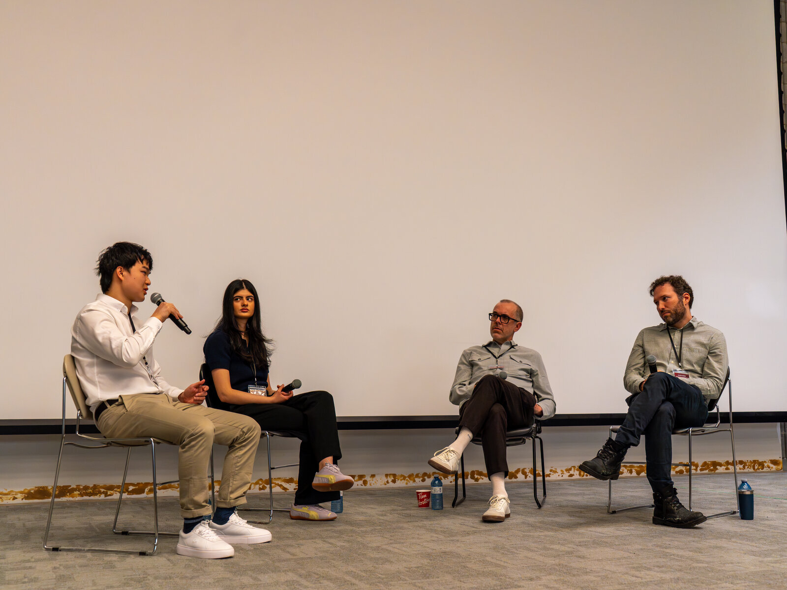 Four speakers on stage for a panel discussion at the SAIL@UofT event.